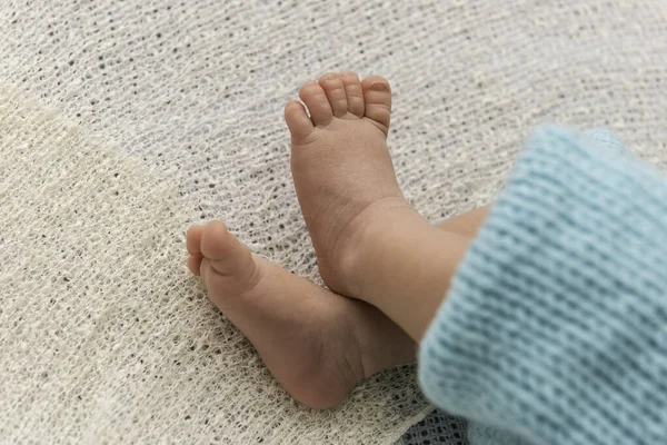 Closeup of a newborn baby feet with beautiful selective focus. Concept for maternity and tenderness