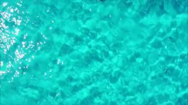 La Pelosa sahilinde, Stintino, Sardinya, İtalya 'da güzel bir turkuaz denizde yüzen bir pedal teknesinin hava manzarası.