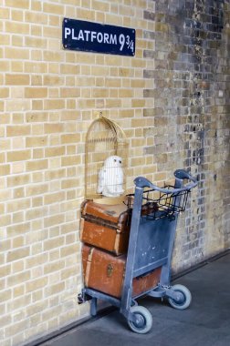 Londra - 31 Mayıs: Harry Potter hayranları tarafından fotoğraf işareti için platform dokuz ve üç çeyrek için ile arabası, Londra, 31 Mayıs 2015 ziyaret Kings Cross İstasyonu duvar.