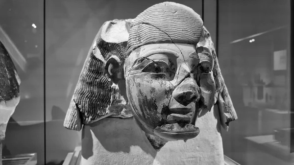 TURIN, İtalya - 10 Kasım 2024: Kısmen hasarlı eski Mısır büstü, karmaşık ayrıntılar ve yıpranmış dokular sergilenen, Mısır Müzesi, Torino, İtalya