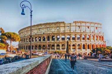 Roma - 31 Mart 2019 'da Roma' da Kolezyum 'un yanından geçen turistler. Kolezyum, Roma İmparatorluğu 'nun simgesel bir sembolüdür. 2007 yılında kompleks, dünyanın New7Wonders of the World arasında yer aldı.