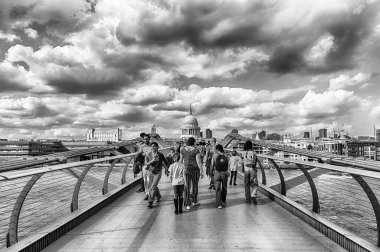 LONDON - 15 Nisan 2022: Millennium Köprüsü üzerinde yürümek, Londra, İngiltere 'de Thames Nehri' ni geçen yayalar için çelik asma köprüsü