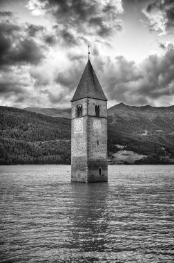 Güney Tyrol, Curon Venosta 'daki Reschensee yapay gölünün suyundan çıkan ikonik eski Graun kilise kulesi.