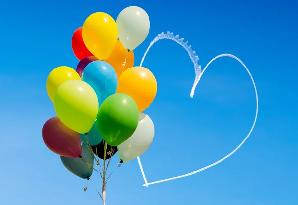 Bunte Luftballons und Herzen mit Flugzeugen in den Himmel geschrieben — Stockfoto