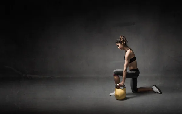 Fille avec kettlebell sur la main — Photo