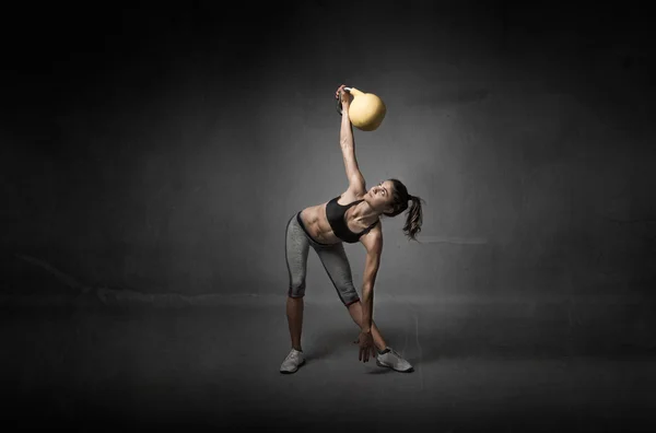 Menina olhando um kettlebell Imagens Royalty-Free