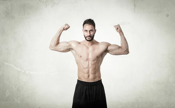 Man showing muscles in abstract room Royalty Free Stock Images