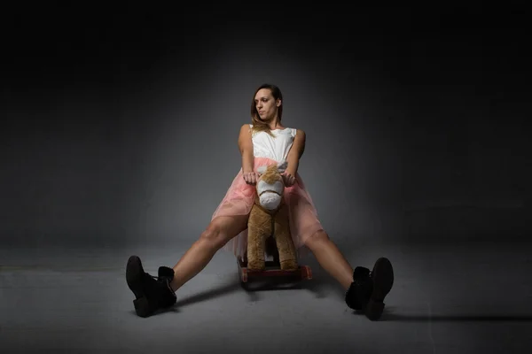 Menina montando um cavalo de balanço — Fotografia de Stock