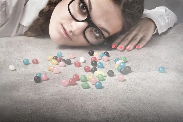 Chica en gafas mirando caramelos — Foto de Stock