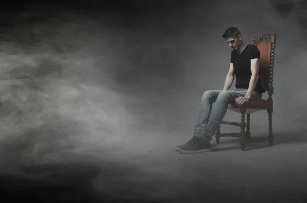 Oturan adam ve bir sandalye üzerinde düşünmek — Stok fotoğraf