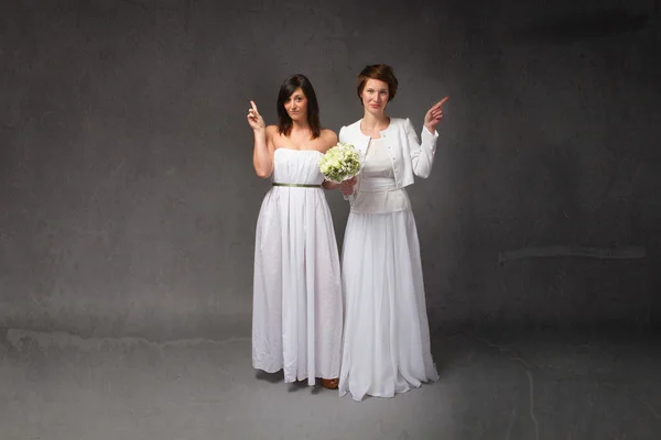 Two brides indicating empty space — Stock Photo, Image