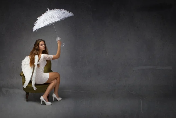 Feminino anjo sentado com guarda-chuva branco — Fotografia de Stock