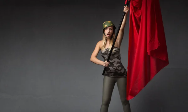 Военная женщина с красным флагом на руке — стоковое фото