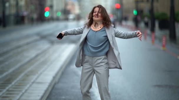 Funny adult woman with neck brace is dancing jokingly on city street, osteochondrosis or cervical flexion injury — Stock Footage Funny adult woman with neck brace is dancing jokingly on city street, osteochondrosis or cervical flexion injury Stock Video