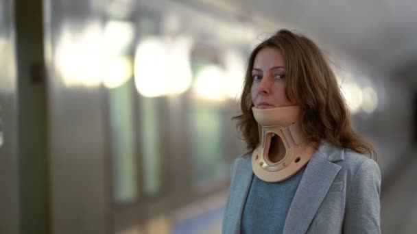 Woman with osteochondrosis is standing in metro station, wearing neck brace for curing ache in spinal — Stock Footage Woman with osteochondrosis is standing in metro station, wearing neck brace for curing ache in spinal Royalty Free Stock Footage