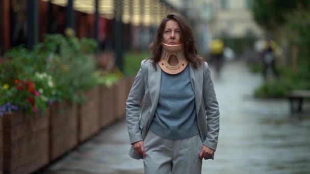 Adult lady is walking in city, wearing cervical collar for curing injury of neck, illness of spinal — Stock Footage Adult lady is walking in city, wearing cervical collar for curing injury of neck, illness of spinal Royalty Free Stock Video
