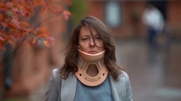 Portrait of sad woman with injury of spine or neck outdoors, lady is wearing cervical collar for curing ache — Stock Footage Portrait of sad woman with injury of spine or neck outdoors, lady is wearing cervical collar for curing ache Royalty Free Stock Footage