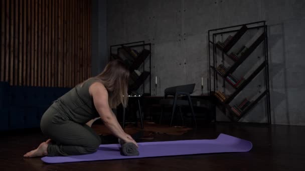 Japanese method of treating back pain, woman is rolling towel and lying on it, stretching spin — Stock Footage Japanese method of treating back pain, woman is rolling towel and lying on it, stretching spin Video Clip