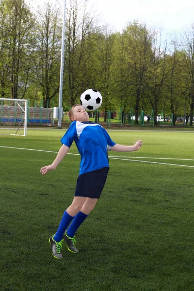 Menino joga futebol — Fotografia de Stock