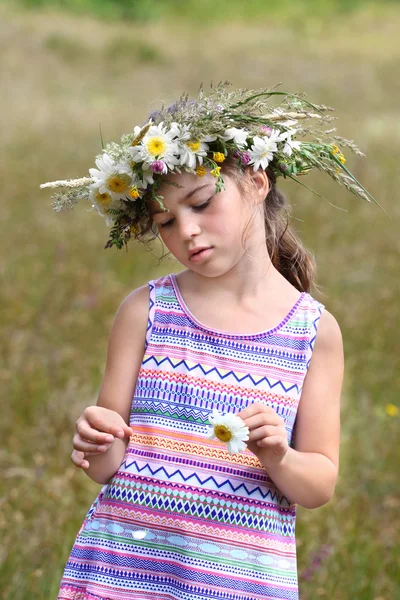 Girl tears off petals of daisy — Stock Photo, Image