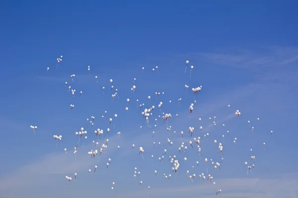 Bílé balónky a modrá obloha — Stock fotografie
