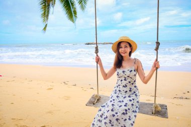 Tayland 'ın Phang Nga eyaletindeki Khao lak deniz fenerinde Nang Tanga Sahili' nin arka bahçesinde sallanan güzel bir kız. Güzel kayalar var seyrek, yumuşak beyaz kum.