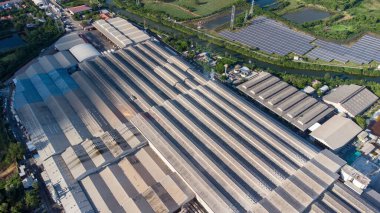 Havadan kuş bakışı fabrika çatısı. Endüstriyel ve yeşil alanların bulunduğu geniş bir sanayi alanı.