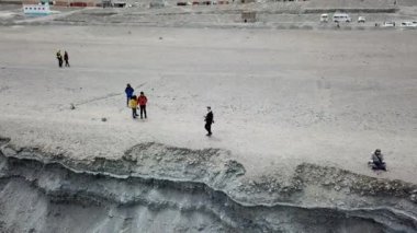 Buzda yürüyen Asyalı adama 4K. Donmuş Göl 'ün mavi buz yüzeyi Pangong Gölü' nden veya Pangong Tso 'dan, Tso moriri Nubra, Hindistan. Soğuk kış, huzur ve özgürlük kavramı