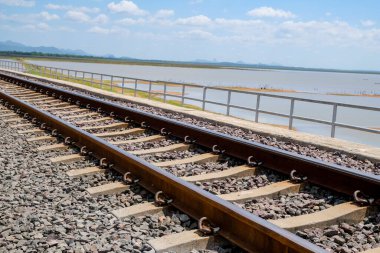 Köprüdeki suyun arka planında demiryolu raylarına odaklan