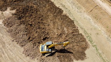 Kazı makinesi ya da kepçeyle kuş bakışı bir toprak katmanını İHA 'dan kazıyarak temizliyor