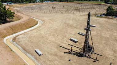 Yığınla ekipman toprağa kazık dikmek için güneş çiftliği için hazırlık, temel inşaatında direklerin çalışması için ağır makineler. İHA 'dan havadan görüntüleme yüksekliği.