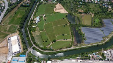 Kuş bakışı güneş çiftliği. Alanın çevresini çevreleyen yeşil doğalı havadaki güneş hücresi istasyonu.
