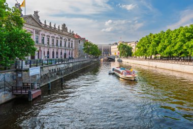 Berlin, Almanya - 8 Temmuz 2011: Zeughaus (Alman Tarihi Müzesi) ve Lustgarten arasında Spree Nehri 'nin batı kolu. Tek bir tur teknesi günün sonunda yola çıkıyor..