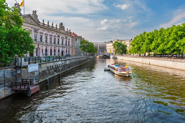 Berlin, Almanya - 8 Temmuz 2011: Zeughaus (Alman Tarihi Müzesi) ve Lustgarten arasında Spree Nehri 'nin batı kolu. Tek bir tur teknesi günün sonunda yola çıkıyor..