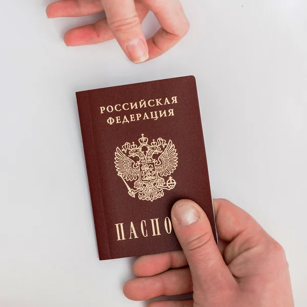 Pasaporte ruso en mano sobre fondo blanco —  Fotos de Stock