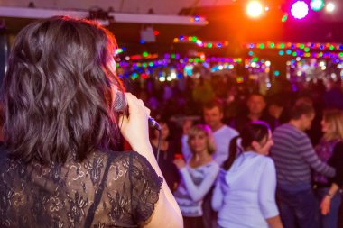 mikrofona partisinde şarkı söyleyen genç kız