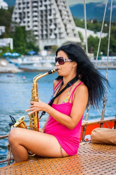 Fille jouant du saxophone sur un yacht en mer — Photo