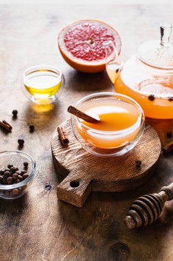 Baharatlı greyfurt çayı ve cam bardakta bal ve ahşap zemin üzerinde çaydanlık. Alternatif tıp konsepti.