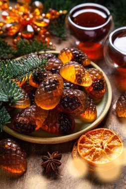 Seramik tabakta marmelat kozalakları ve ahşap zeminde çam dalları. Bir Noel kartı..