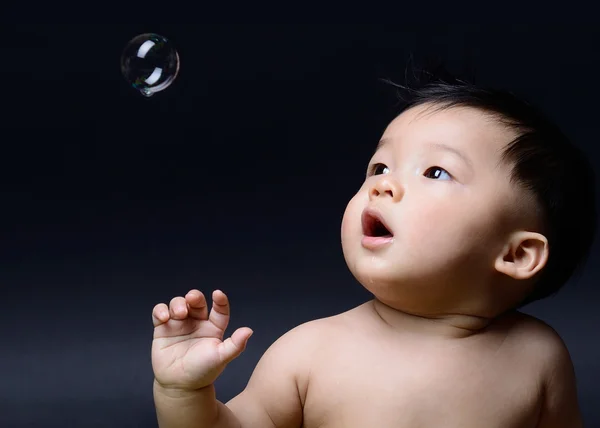 Pequeno bebê ásia menino babando e olhando sabão bolha — Fotografia de Stock