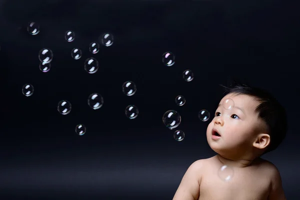 Little baby asian boy looking soap bubbles. — Stock Photo, Image