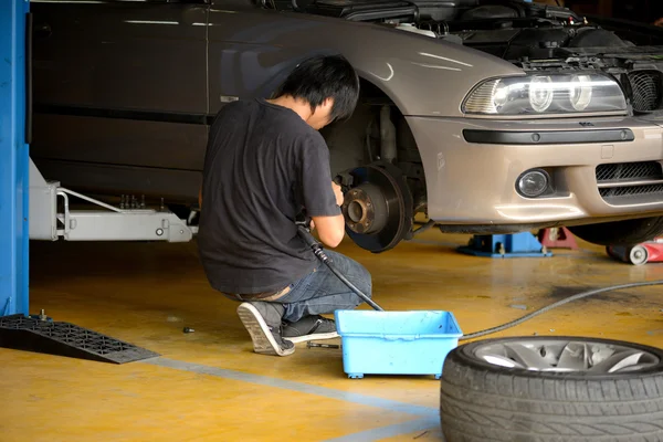 Mechanic removing wheel to check disc brake — Stock Photo, Image