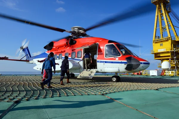 The helicopter landing officer take care passenger to embark hel — Stock Photo, Image