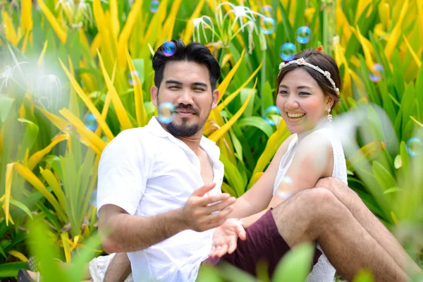 Gelukkige Aziatische paar spelen samen met zeepbel tuin — Stockfoto