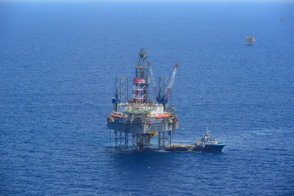 La plate-forme pétrolière de forage offshore et bateau de ravitaillement vue de côté — Photo