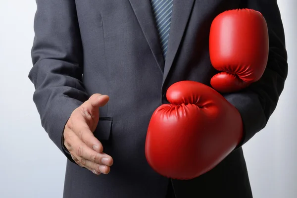 Geschäftsmann zieht Boxhandschuhe aus, um einen Händedruck auf weißem B anzubieten — Stockfoto