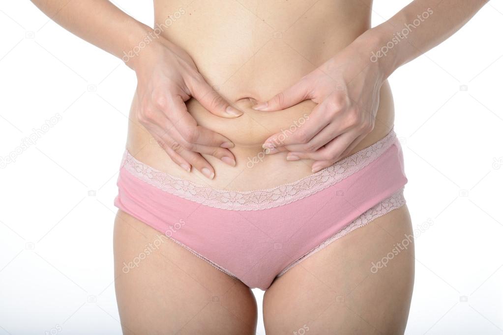 asian woman checking her fat by pinching her belly with fingers