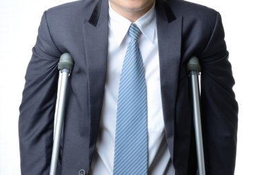 injured businessman with crutches, insurance concept clipart