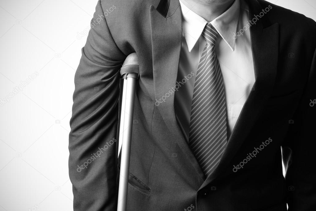 injured businessman with crutches, insurance concept