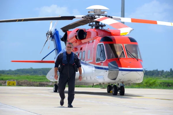 Caucásico piloto de helicóptero offshore está caminando y sonriendo besid —  Fotos de Stock